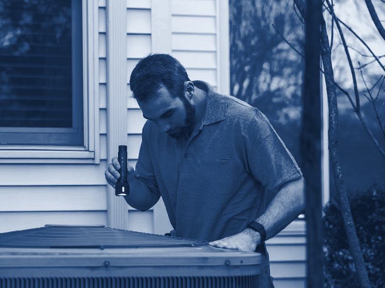 A technician checking an outdoor air conditioning unit